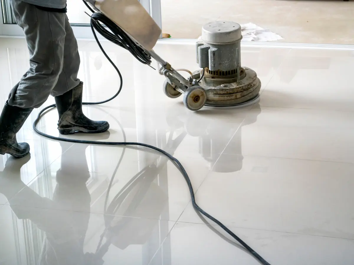 A commercial cleaner polishing a tile floor with a floor buffer.