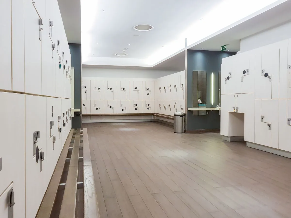 Empty gym locker room with clean floors, showing results of a professional gym floor cleaning service.