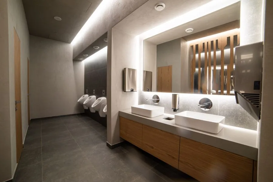 Modern restroom with clean sinks and urinals maintained by professional government cleaning services.